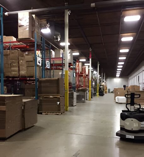 Warehouse interior with stacked boxes and equipment.
