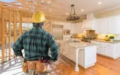 Construction worker observing kitchen renovation progress.