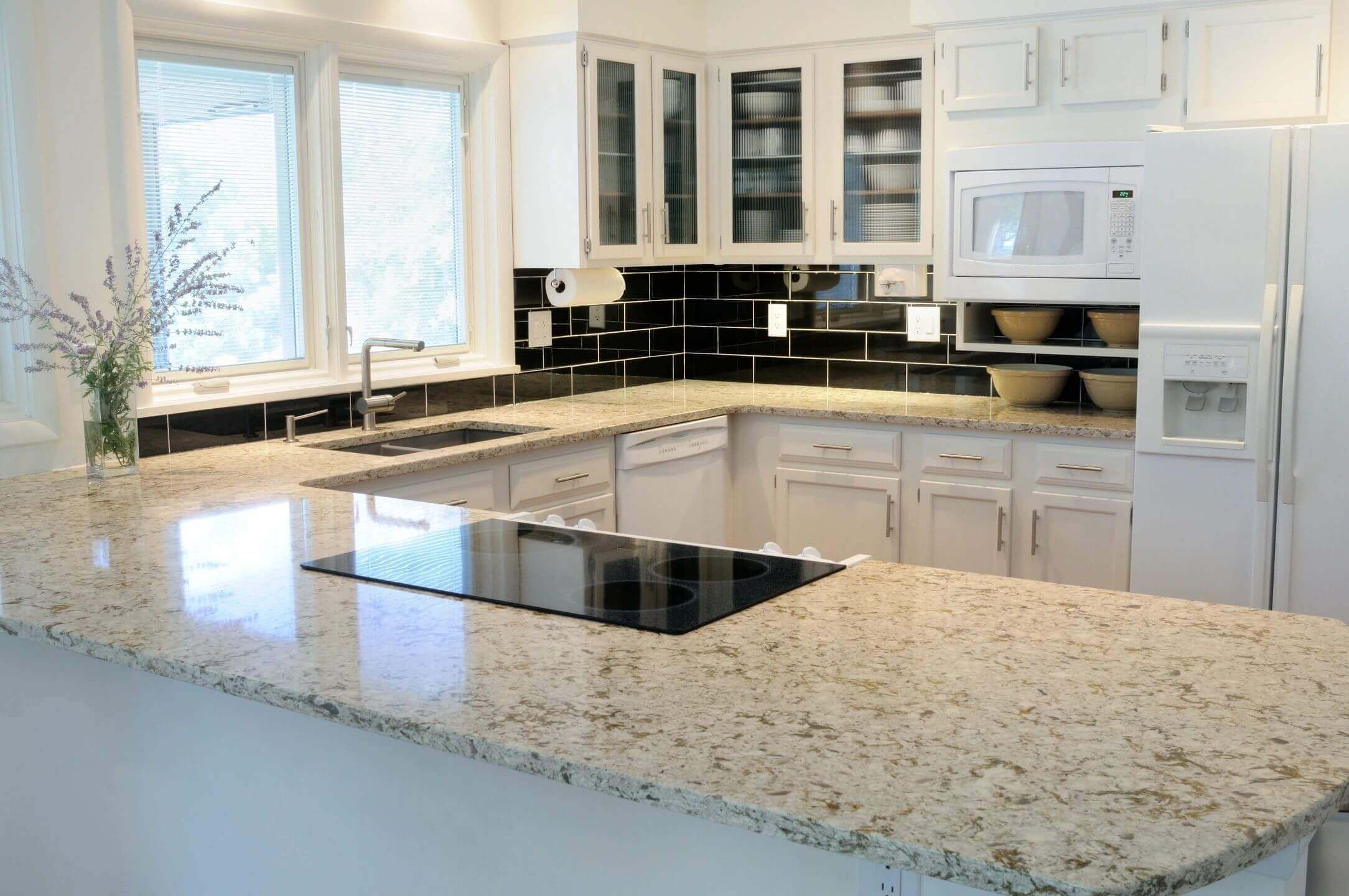 Modern kitchen with granite countertops and appliances.
