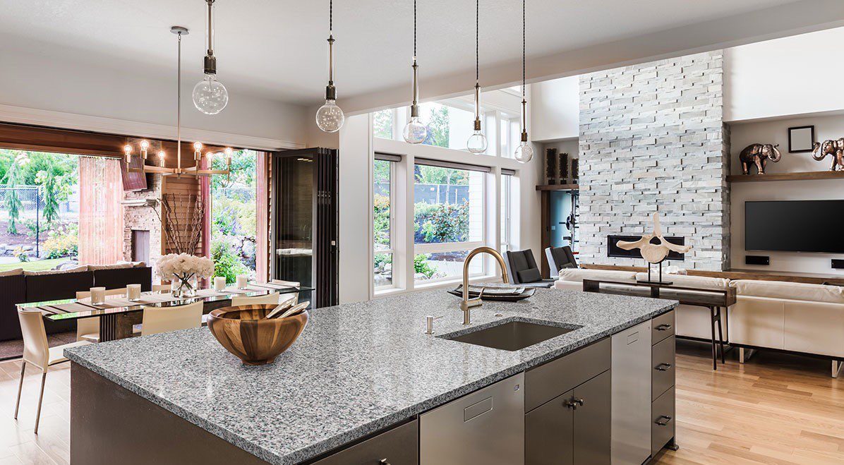 Modern kitchen with granite island and fireplace.