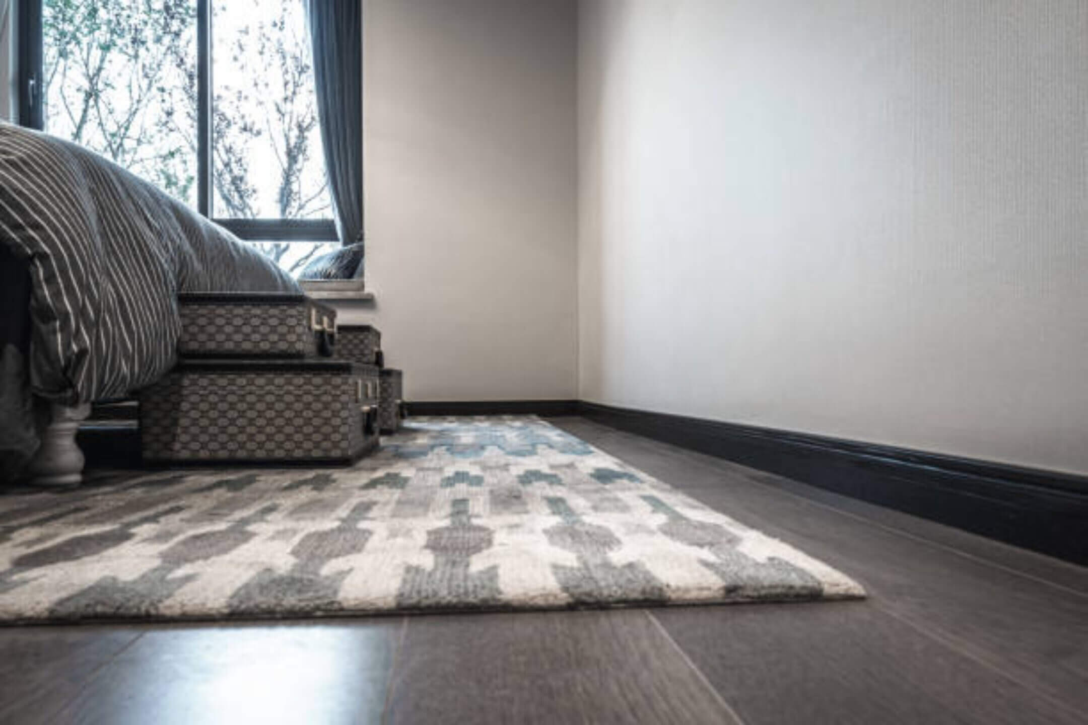 Bedroom with patterned rug and suitcase stack.